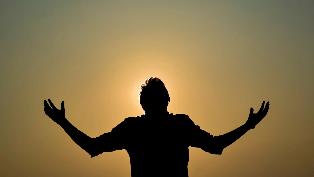 A silhueta de um homem ergue os braços diante do céu dourado do entardecer, em um gesto que sugere abertura e renovação. Depois de refletir sobre a força das tristezas e das lembranças que permanecem, o autor encontra na possibilidade de recomeçar a cada dia uma nova chance de ser feliz