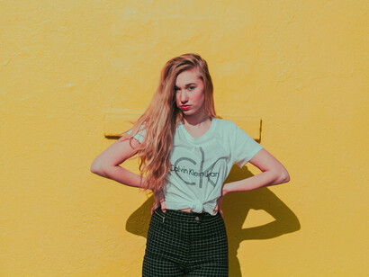 Mujer posa para una foto con un fondo amarillo