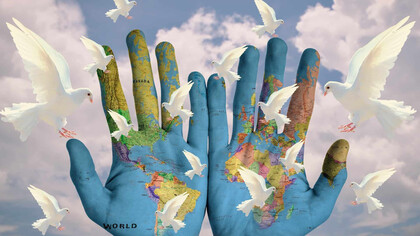 Hands painted with the world, doves of peace flying about