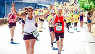 A group of marathon runners approaching the finish line, looking happy and proud to have completed the run