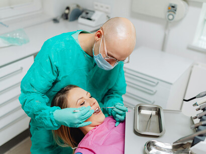 A woman receiving a routine dental check-up, reflecting the everyday use of modern medical technology in high-income countries