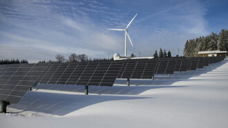 Solarpark und eine Windmühle in einer Winterlandschaft