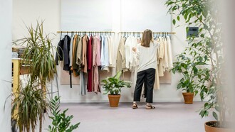 Mulher escolhe roupas em uma arara de loja. Mais do que estilo, cada escolha revela valores e um novo olhar sobre o consumo consciente. Entre peças e possibilidades, a decisão vai além da estética. Consumir moda hoje também é um ato de responsabilidade