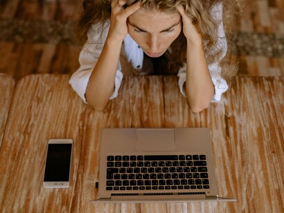 Mulher frustrada em frente ao computador. A ambição realizada é também o vazio instalado e acompanhado constantemente do medo de perder ou de nada mais conseguir. O receio de deixar de significar gera muita ansiedade e também despersonaliza