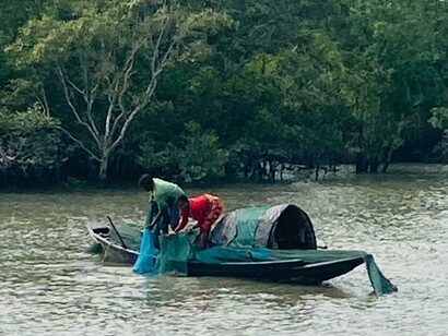 Les pêcheurs, silencieux dans leurs bateaux, affrontent l'incertitude du delta sous le regard vigilant de la jungle du fleuve Gange, en Inde