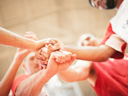 Men playing college basketball go in for the fist bump