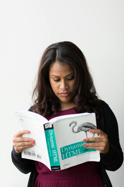 Professora estuda livro sobre linguagem HTML