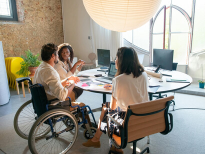 A group of people having a meeting in an accessible office space that supports disability inclusion in the workplace