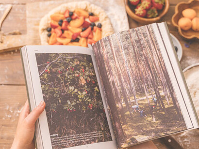 In a charming kitchen setting, a woman effortlessly prepares a meal using a cookbook, epitomizing the simplicity and satisfaction of home cooking