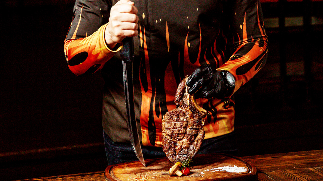 A chef puts meat on the cutting board