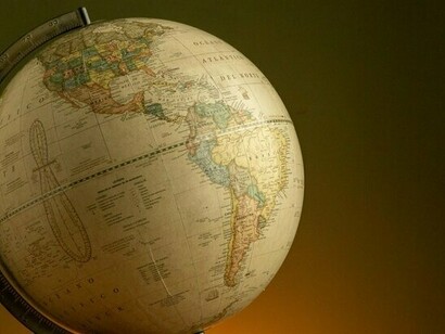 A vintage globe resting in shadow, representing the fragile international order shaped after World War II