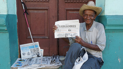 A street vendor selling the *Trabajadores* newspaper in Santiago de Cuba, Cuba