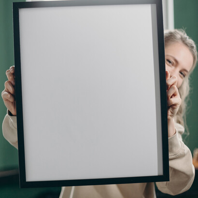 Minimal. Ragazza che sorride dietro una cornice vuota