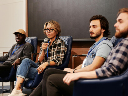 People gather at an innovation conference panel, engaging in discussion together