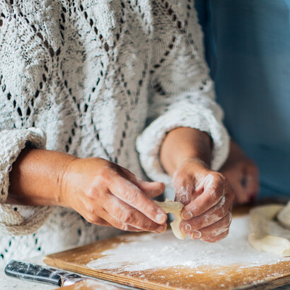 Filha ajuda a mãe a preparar massa de bolinho de chuva para aniversário intimista