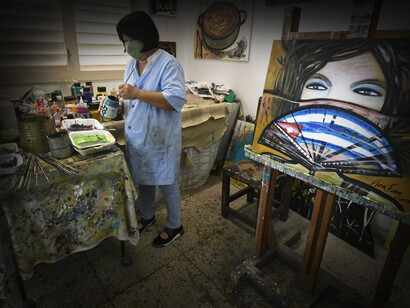 Flora Fong en su taller en Cuba retocando una de sus obras