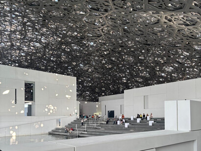 Sous le toit anthracite du Louvre Abu Dhabi, chaque rayon de lumière transforme la promenade en un voyage à travers le temps et les civilisations