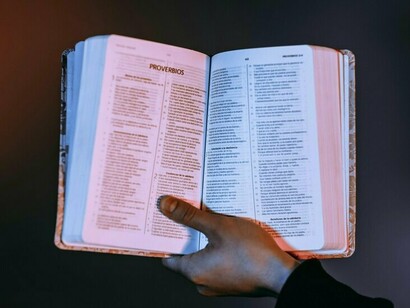 A hand presenting an open Bible, conveying the importance of grounding one’s life in God’s word