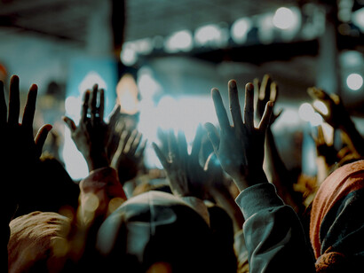 Protesters standing together with raised arms, representing community power versus the state