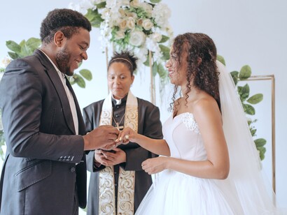 Noivo coloca anel de casamento no dedo da noiva