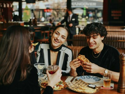 A group of friends gathered around food, engaged in lively conversation, symbolizing the joy of human connection beyond screens