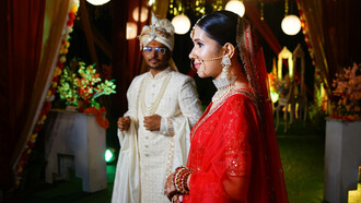 A radiant bride and groom celebrating a traditional Kumaoni wedding, adorned in vibrant attire and cultural splendor