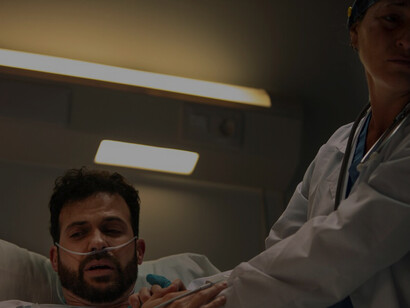 The doctor, with a somber expression, attends to her patient