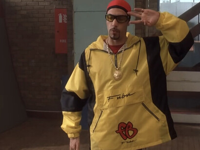Ali G es ridículo porque trata de ser un gánster, pero vive con su madre; tunea su coche, que no supera los 50 kilómetros por hora; viste tratando de emular a gente como Tupac, pero rapea torpemente y se cae al intentar hacer un paso de breakdance