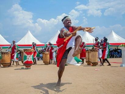 Un danseur en costume de cérémonie burundais exécutant une danse traditionnelle, symbolisant les racines culturelles qui ancrent le sentiment d'appartenance à la communauté