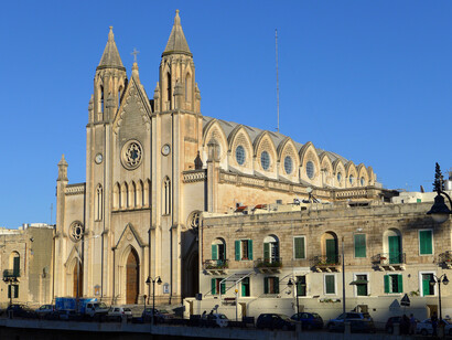 Iglesia neogótica de Nuestra Señora del Monte Carmelo de Balluta, San Julian, al noroeste de Valleta, atardecer bajo la luz del sol, situada en la bahía, Malta