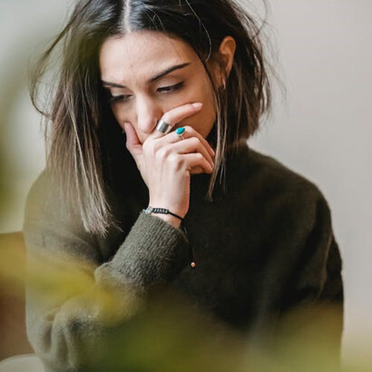 The girl in the green sweater exudes a sense of melancholy, her expression conveying deep sadness or despondency