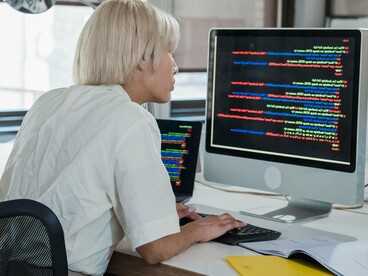 Programadora executa atividades técnicas em seu computador. O crescimento da inteligência artificial reacendeu o debate sobre igualdade de oportunidades no setor tecnológico. Especialistas defendem que sistemas mais inclusivos começam com equipas mais representativas. A diversidade de perspectivas ajuda a identificar problemas que poderiam passar despercebidos