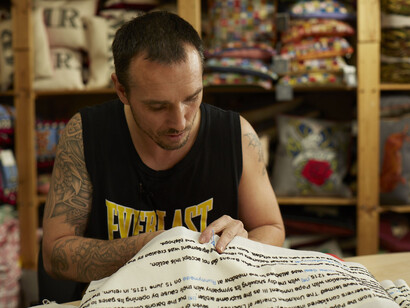 Chris Parsons, a member of Fine Cell Work, at work on Magna Carta (An Embroidery) by Cornelia Parker, Photograph by Joseph Turp 