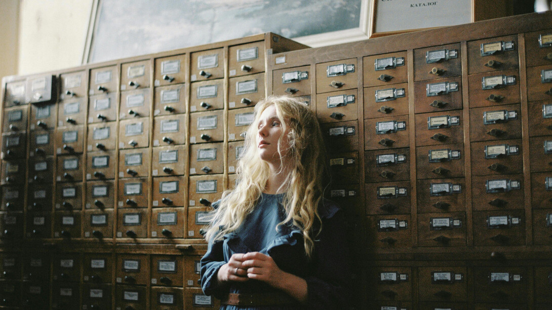 Mulher reflexiva em meios aos arquivos. Então se o princípio de organização que parece dar sentido aos arquivos se dá pela gestão de informação