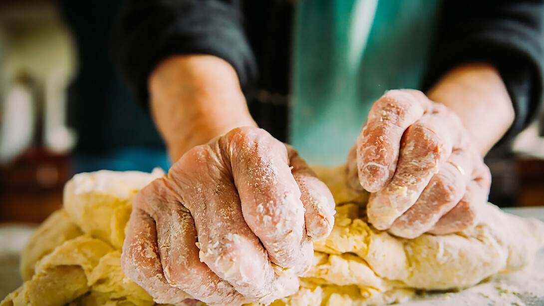 Close-up of an elderly Italian woman’s hands making fresh pasta by hand