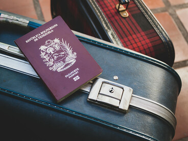 Mérida, Venezuela, a Venezuelan passport lies on a locked leather suitcase, reflecting restricted mobility