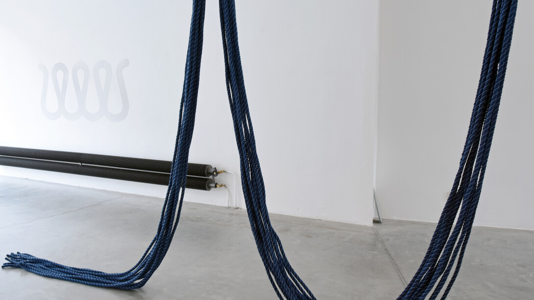 Kato Six, Untitled (heads or tails), 2019. 150 meters of cotton rope (foreground), Dust from black mdf (background). Photgrapher: Sybilla Britani. Installation view in the artist studio.