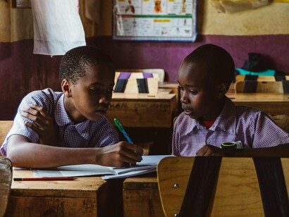 Young students studying side by side in a classroom, reflecting the importance of education in cultivating shared civic values