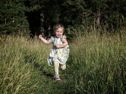 Niña jugando en un campo análogo