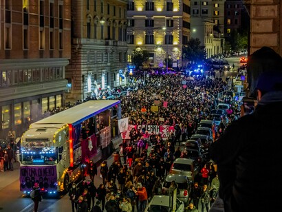 A large nighttime demonstration fills the streets with protesters and banners in Rome, Italy