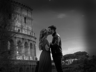 A couple in love, kissing in front of the colosseum in Rome, Italy