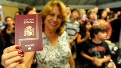 Una mujer muestra su pasaporte español