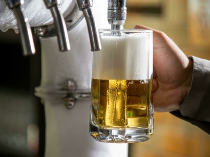 Hands pouring beer at a craft brewery, showcasing the beer-making process