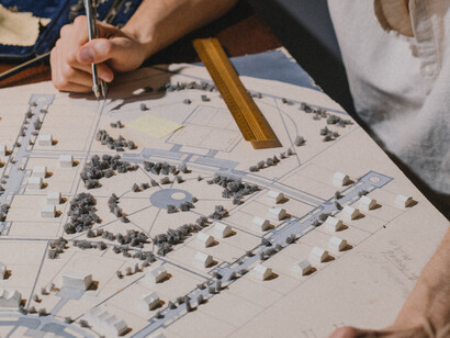 An architect looking at the spatial differences in his drawing and markers 