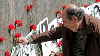 Un hombre deposita una flor ante un altar en recuerdo a los desaparecidos en Chile