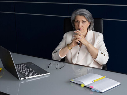 An elderly woman actively contributing in a professional office setting