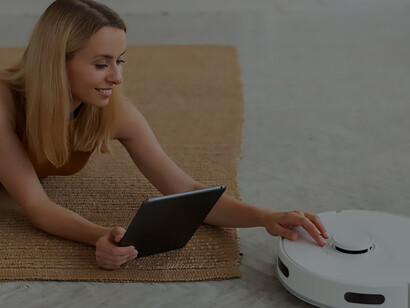 Enhance your home cleaning routine with a robot vacuum cleaner, witnessing how effortlessly a person utilizes this innovative technology for a pristine living environment