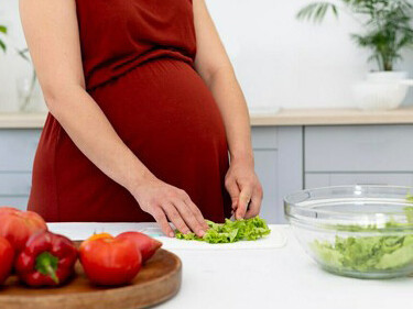 A mother-to-be cooking a balanced dinner, promoting a healthy pregnancy