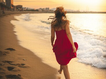 A mulher segue pela faixa de areia molhada, acompanhando a linha da água e o movimento das ondas. Estar em paz com as próprias escolhas não significa ter todas as respostas, mas aprender a reconhecer os próprios limites e respeitar os caminhos diferentes dos demais