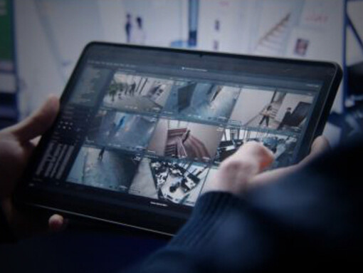 The security operator uses a tablet to control and adjust CCTV cameras, ensuring effective surveillance coverage